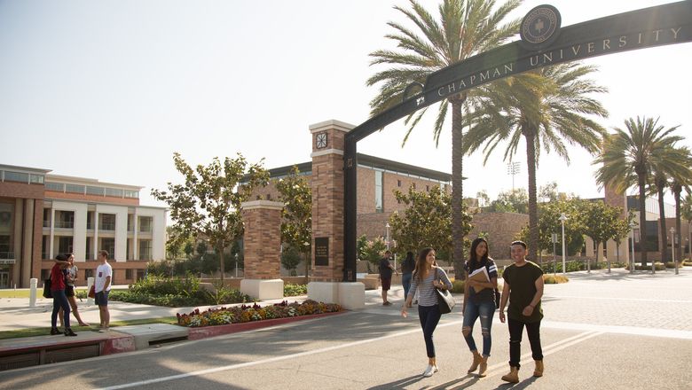 Students walk on the Chapman campus at sunset.