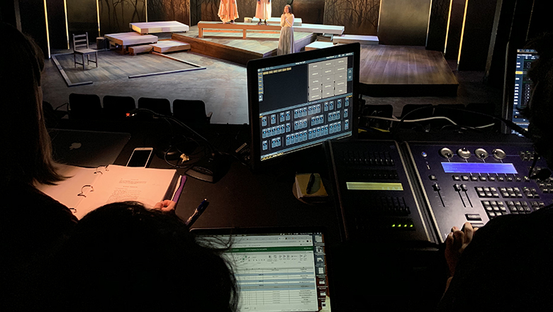 Technical theatre students monitoring sound and lighting of a stage