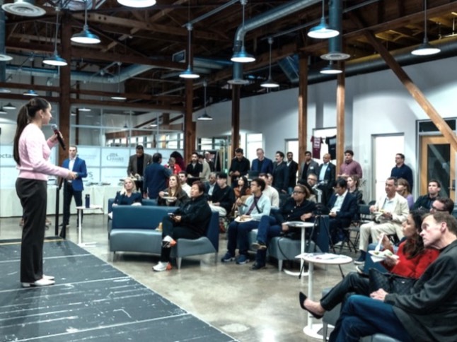 a large group of people sitting and standing in a large room