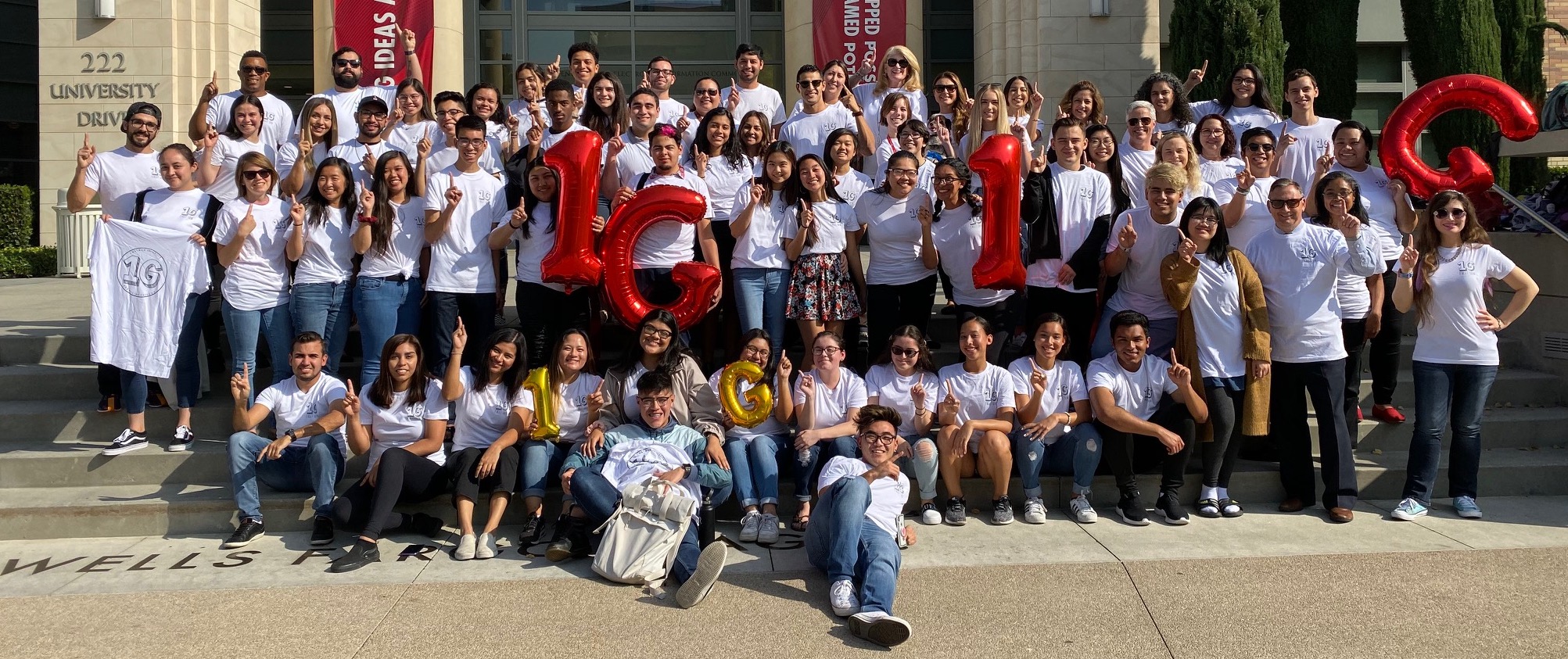 first-gen community members of Chapman University pose for photo holding "1G" balloons