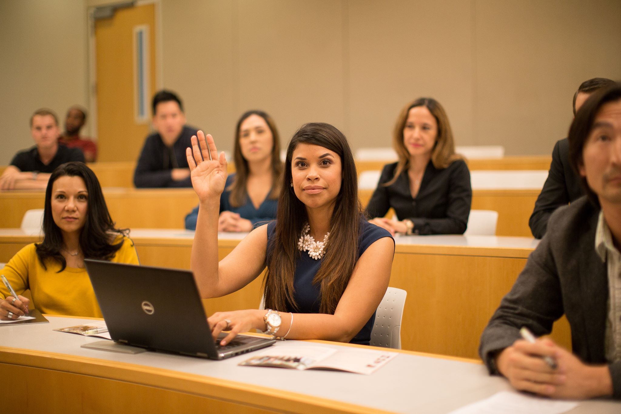 MBA student raising hand in classroom