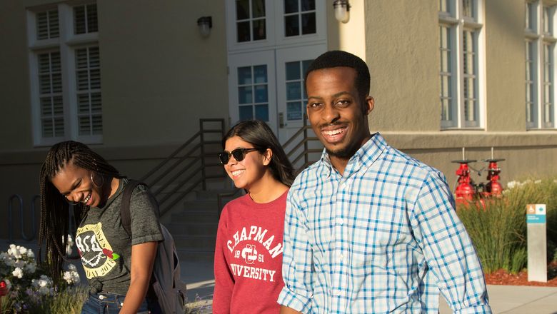 Three students walk on campus