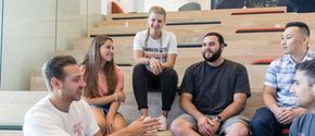 Students sitting on a large staircase and talking with each other