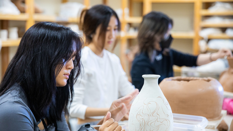 Two students working on a pottery project