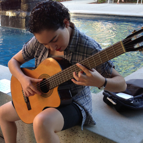 student playing a classical guitar