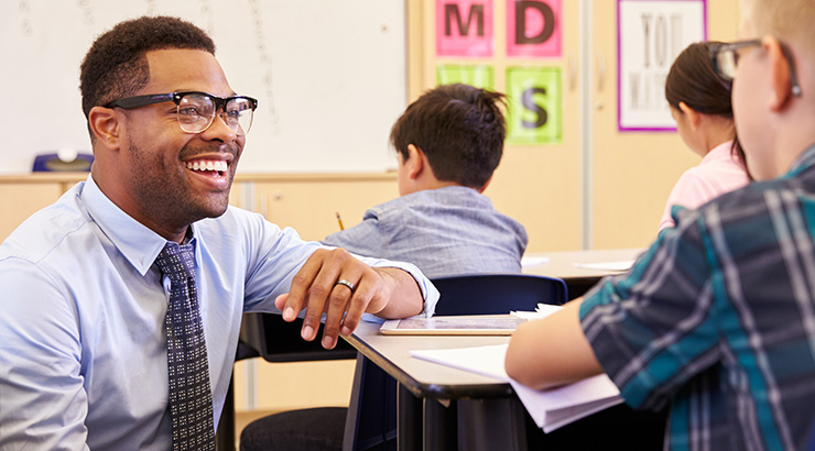 Black male  teacher smiling at student