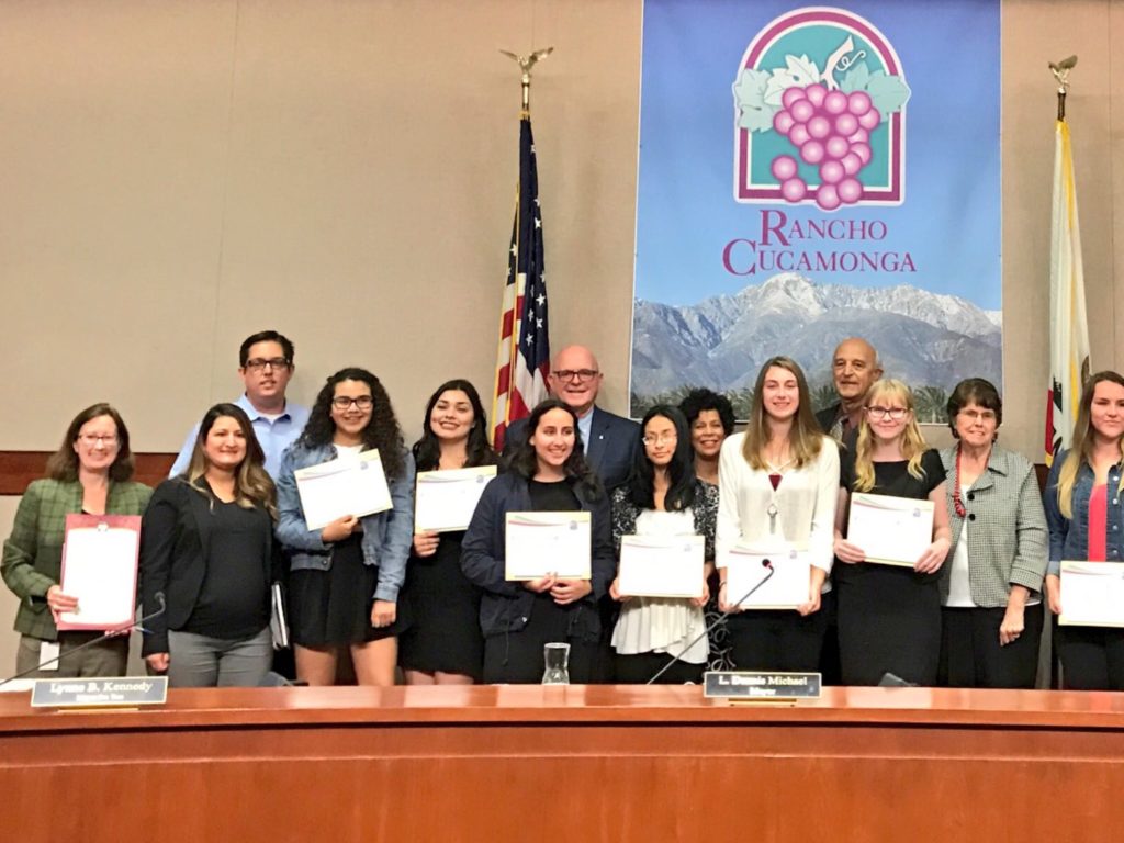A group of teen students and teachers stand holding certificates in the Rancho Cucamonga City Council Chamber