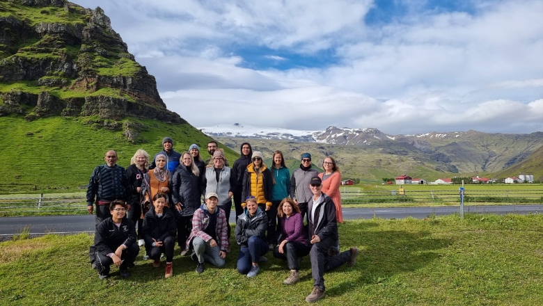 students on grass field in front of mountain in Iceland