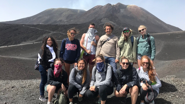 Students on dark gray volcano in Italy