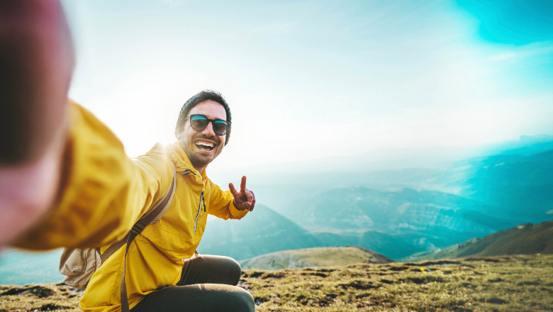 Guy taking selfie on top of a mountain