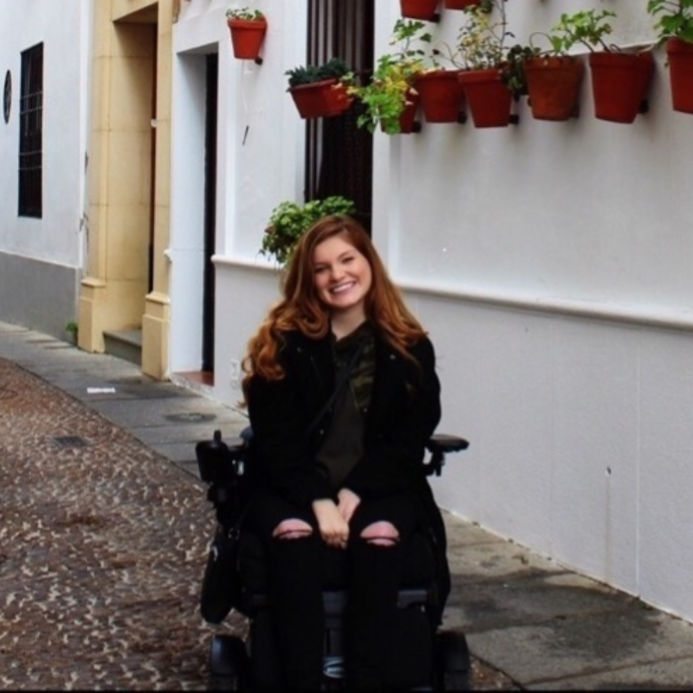 Student in wheelchair on cobblestone street in Spain