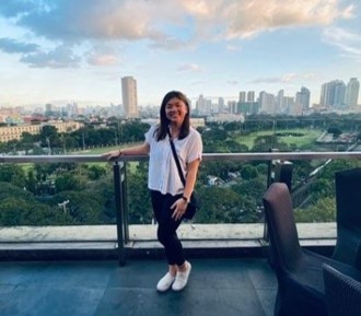 Female student on balcony overlooking city in the Philippines