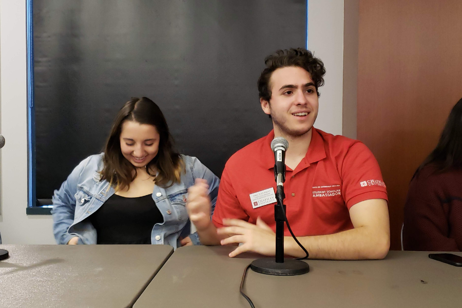 Students talk in front of microphones at panel