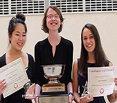 three students posing with awards