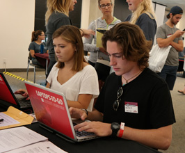 Student sitting at computer with name tag