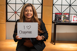 Female staff member holding sign that says "I love Chapman"